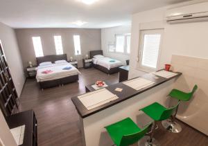 a room with two beds and a desk with green chairs at Guesthouse Stari Grad in Mostar