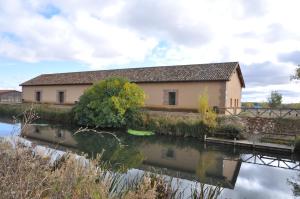 un bâtiment à côté d'une masse d'eau dans l'établissement Carrecalzada, à Melgar de Fernamental