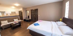 a bedroom with a bed and a couch and a table at Guesthouse Stari Grad in Mostar