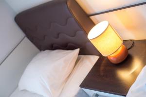 a bed with a black headboard and a lamp on a table at Guesthouse Stari Grad in Mostar
