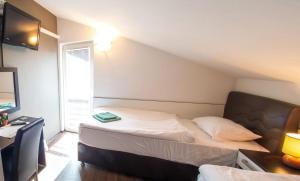 a small bedroom with a bed and a window at Guesthouse Stari Grad in Mostar