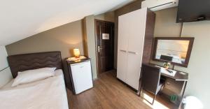 a small bedroom with a bed and a mirror at Guesthouse Stari Grad in Mostar