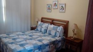 a bedroom with a bed with a blue and white comforter at Pousada Berço da Liberdade in Tiradentes