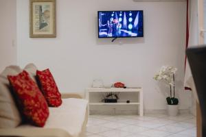 ein Wohnzimmer mit einem Sofa und einem TV an der Wand in der Unterkunft Apartment and Room Old town in Split