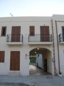 a white building with wooden doors and a tunnel at Annalisa Apartments 250 dal mare in San Vito lo Capo