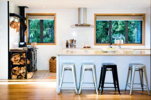 a kitchen with a large island with two bar stools at Wanaka Tree & Lake House in Wanaka
