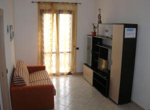 a living room with a couch and a refrigerator at Annalisa Apartments 250 dal mare in San Vito lo Capo