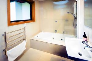 un baño con bañera y lavabo en Wanaka Tree & Lake House, en Wanaka 17 fotos más