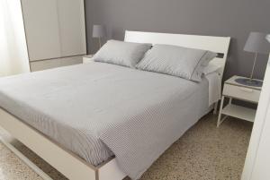 a bedroom with a white bed and a night stand at Caselita in Palermo