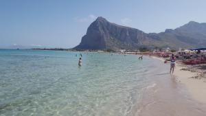 a group of people in the water at a beach at Annalisa Apartments 250 dal mare in San Vito lo Capo