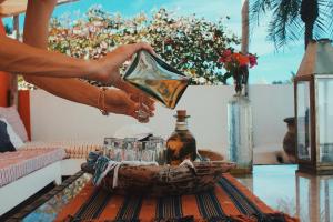 une personne versant une boisson d'un pichet de verre dans l'établissement Petit Hotel Hafa, à Sayulita