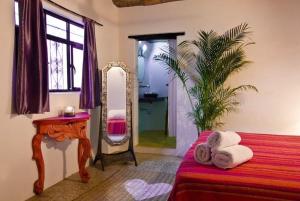 a bedroom with a mirror and a bed and a table at Petit Hotel Hafa in Sayulita