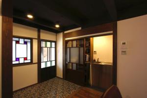 a room with a kitchen with a refrigerator and windows at Azuki an Machiya House in Kyoto