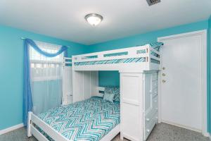 a bedroom with a bunk bed with a white bunk bed at Villa Serenity, Pet Friendly in Panama City Beach +16 photos