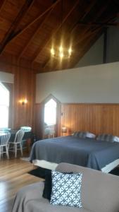 a bedroom with a bed and a table and chairs at St Andrews Church Nave in Ophir