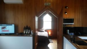 een kamer met een keuken, een raam en een televisie bij St Andrews Church Nave in Ophir