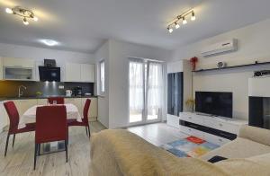 a living room with a dining table and a kitchen at Apartments Elviana in Pula