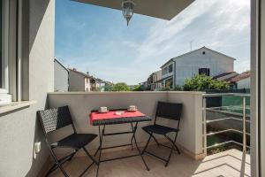 a small balcony with a table and chairs on it at Apartments Elviana in Pula