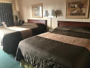 una habitación de hotel con 2 camas y una lámpara en Redwood Inn, en Gadsden