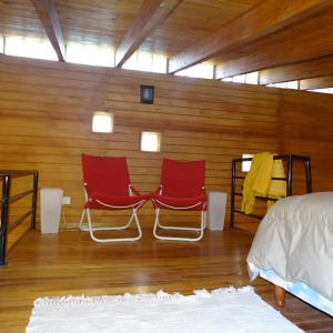 two red chairs sitting in a room with wooden walls at LA AGÜITA PERDIDA in Raco +42 photos