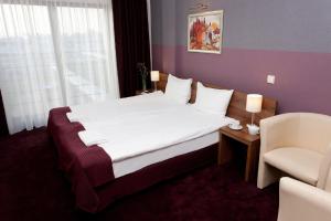 a hotel room with a bed and a chair at Hotel Swing in Krakow