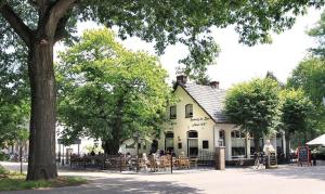 a group of people sitting at tables outside of a building at Herberg de Bos in Swalmen