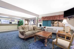 a living room with a couch and a table at Super 8 by Wyndham Carthage in Carthage