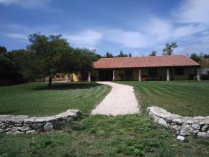 a house with a stone path in front of it at Agriturismo la Mimosa in Putzu Idu