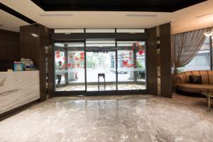 un vestíbulo con una gran puerta de cristal y un sofá en Nan Tou Hotel en Nantou City