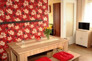 een kamer met een tafel met bloemen op een rode muur bij Ferienwohnung Großmann in Dresden