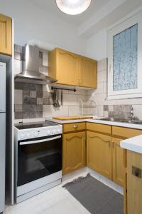 a kitchen with wooden cabinets and a stove top oven at Athens spacious apartment in Athens