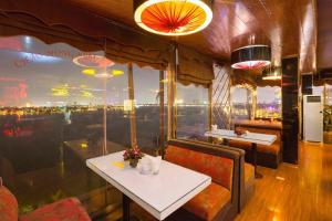 un restaurante con mesa y vistas a la ciudad en Sunset Westlake Hanoi Hotel, en Hanói