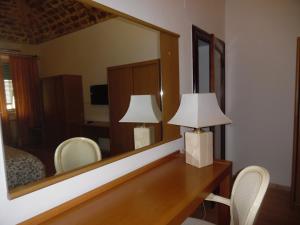 a bedroom with a mirror and a desk with a lamp at Albergo Livorno in Casciana Terme