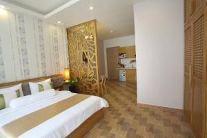 Thuy Sakura Hotel & Serviced Apartment في مدينة هوشي منه: غرفة نوم بسرير كبير ومطبخ