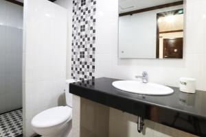 a bathroom with a toilet and a sink and a mirror at Pondok 3 Mertha in Kuta