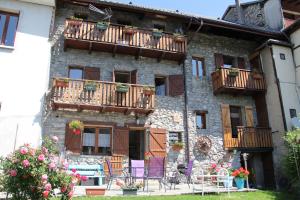 an old stone building with balconies and tables and chairs at juste pour le plaisir in Saint-Pierre-dʼAlbigny