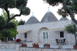 a stone house with a table in front of it at Antiche Dimore TerraRossa in Alberobello