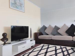 a living room with a couch and a flat screen tv at The Heart of Rotorua in Rotorua