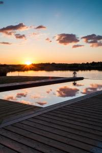 muelle con reflejo de la puesta de sol en el agua en Chambre d’hotes Le Grand Fourneau, en Lassay-sur-Croisne