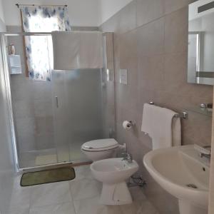 a bathroom with a toilet and a shower and a sink at B&B Letizia in Marina di Lizzano +18 photos