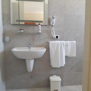 a bathroom with a sink and a toilet with towels at B&B Letizia in Marina di Lizzano