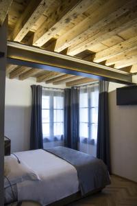 a bed in a bedroom with a wooden ceiling at Hotel Dal Menga in Torrebelvicino