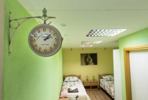 a clock hanging on a green wall in a bedroom at Apartment Skeja in Split