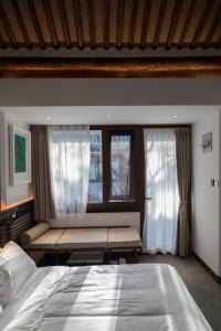 um quarto com uma cama grande e uma janela em Courtyard Guesthouse, Beijing em Pequim