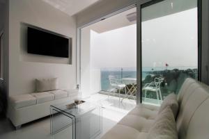 a living room with a white couch and a large window at The White Pearl Suite - beach front city centre with sea view. in Limassol
