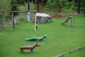 un parque con parque infantil con animales de juguete en la hierba en Locanda La Ruscoletta, en Telve