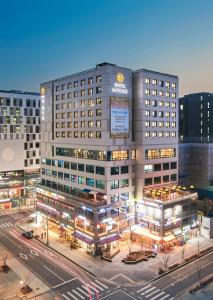 a large building with lights in a city at night at Hotel Mfelice in Seoul