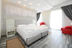 a bedroom with a large bed and a red chair at Front Lake Hotel Villa Paradiso Suite in Moniga