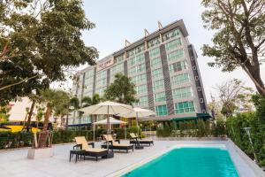 un hotel con piscina frente a un edificio en Top View Hotel - SHA Extra Plus en Si Racha