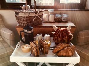 a table with a tray of pastries and coffee on it at The Earsdon Annexe in North Walsham